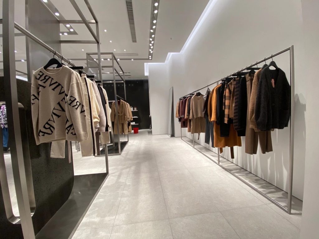 Ceiling mounted track lighting system in fashion showroom highlighting clothing displays with precise beam control