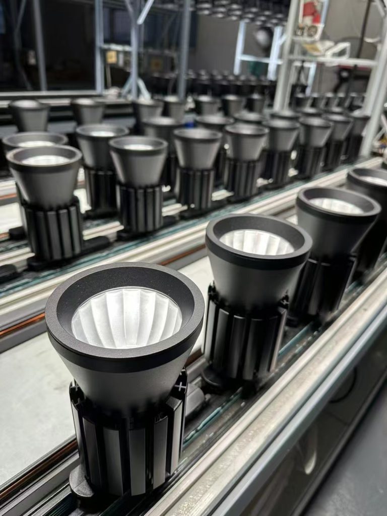 Professional track lighting fixtures assembled on factory production line featuring precision optical reflectors