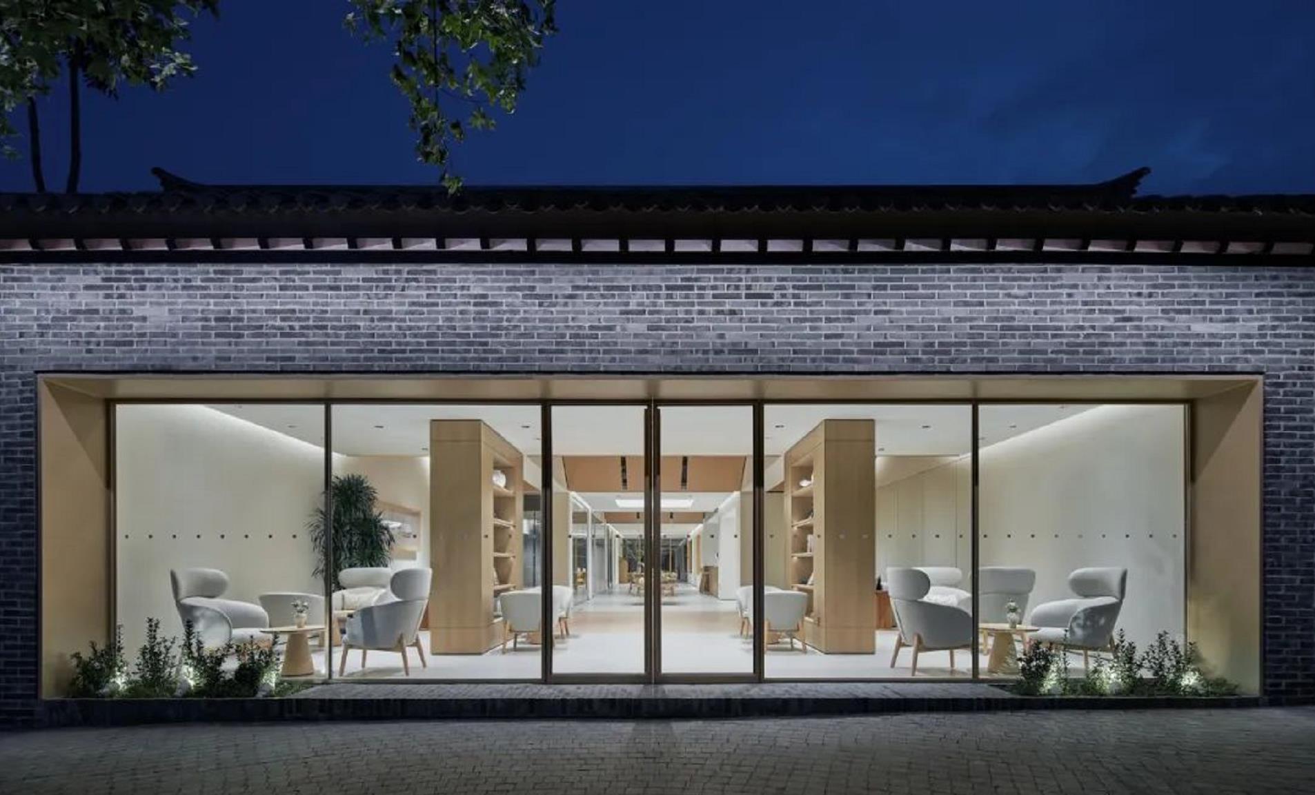 NIO showroom glass facade at night with interior architectural lighting creating a welcoming atmosphere