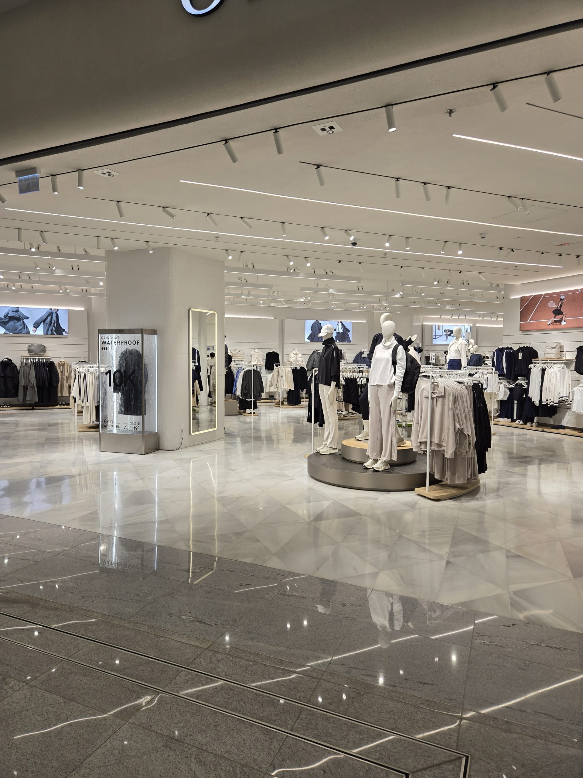 OYSHO fashion retail store interior illuminated with LED track spotlights and architectural ceiling lighting.