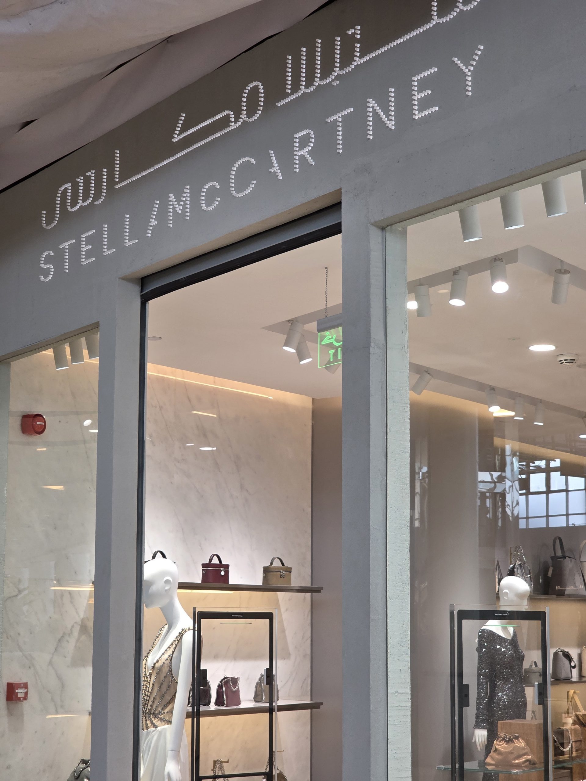 Stella McCartney luxury boutique illuminated with adjustable LED track spotlights highlighting handbags and fashion displays.